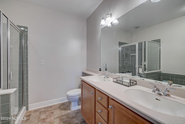 bathroom featuring vanity, toilet, and an enclosed shower