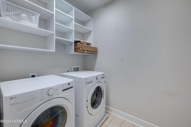 laundry area featuring light tile patterned floors and washer and clothes dryer