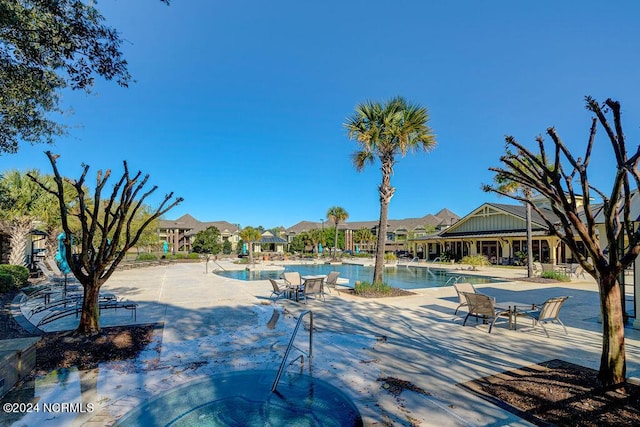 view of pool with a hot tub and a patio