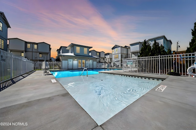 pool at dusk featuring a patio