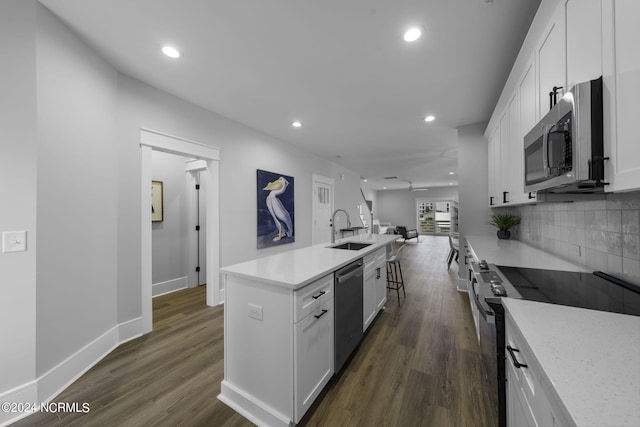 kitchen with white cabinets, stainless steel appliances, sink, and dark hardwood / wood-style flooring