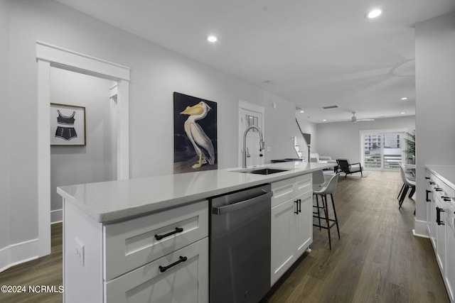 kitchen with an island with sink, white cabinets, dishwasher, dark hardwood / wood-style flooring, and sink