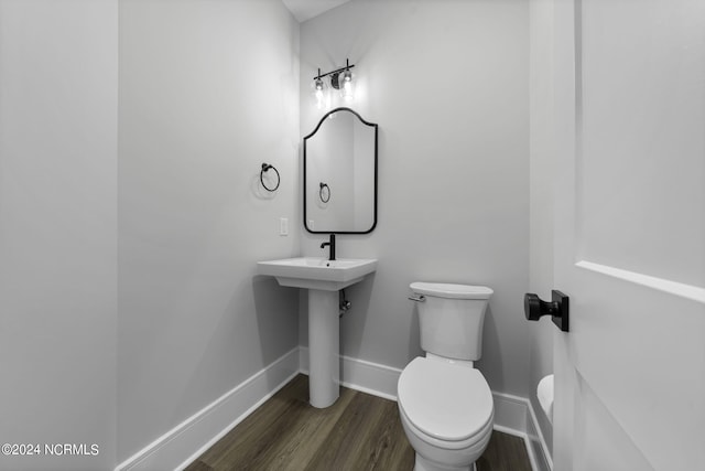 bathroom with hardwood / wood-style flooring and toilet