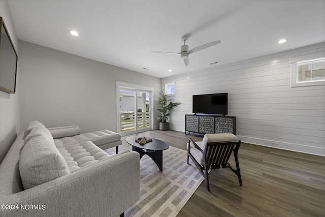 living room with ceiling fan and dark hardwood / wood-style flooring