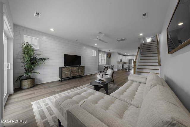 living room with ceiling fan and light wood-type flooring