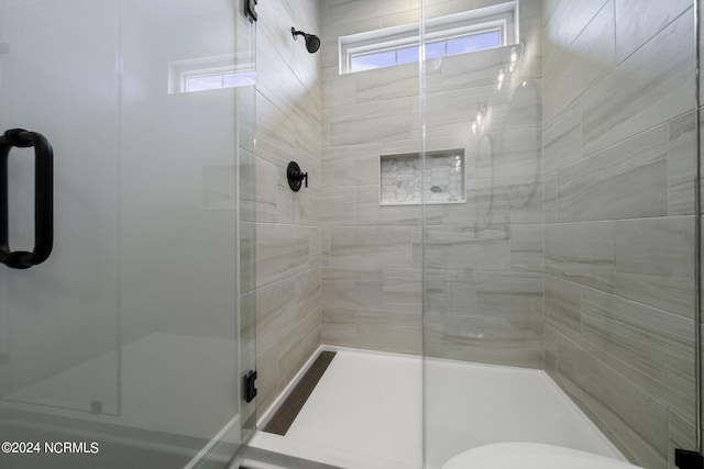 bathroom featuring a shower with door