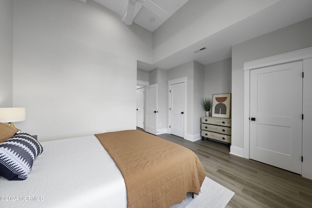 bedroom featuring ceiling fan, a closet, hardwood / wood-style floors, and a high ceiling