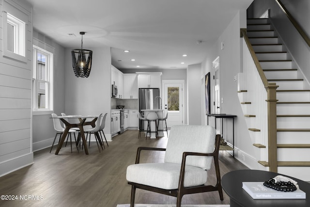 living room featuring dark hardwood / wood-style floors, a chandelier, and a healthy amount of sunlight