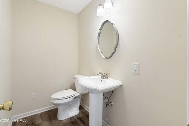 bathroom with hardwood / wood-style flooring and toilet