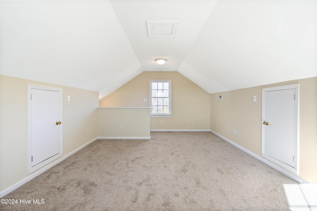 additional living space with light colored carpet and vaulted ceiling