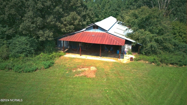 exterior space featuring a wooded view and a lawn