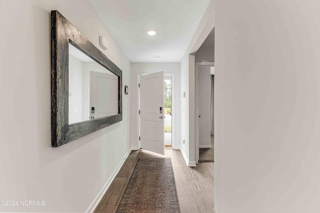 corridor with hardwood / wood-style flooring