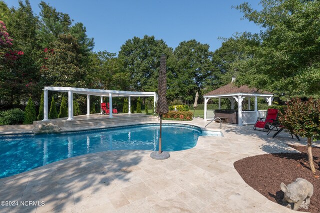 view of swimming pool featuring a patio, a gazebo, and a hot tub