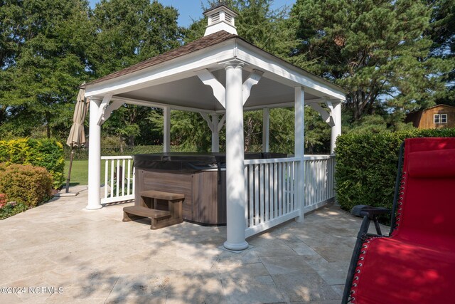 view of patio / terrace featuring a hot tub and a gazebo