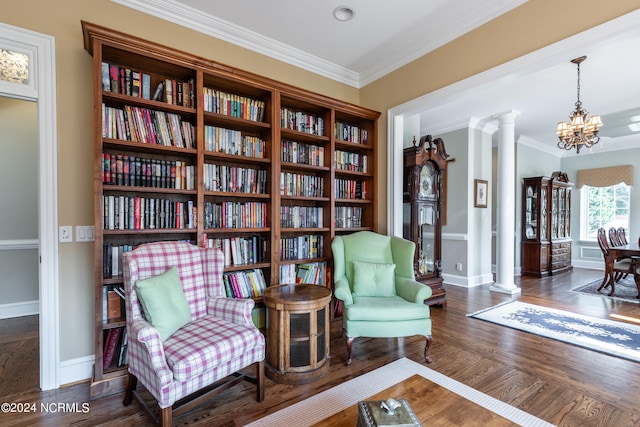 sitting room with decorative columns, crown molding, dark hardwood / wood-style flooring, and a notable chandelier