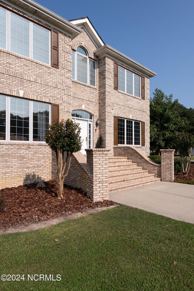 view of front of home with a front yard and a patio area