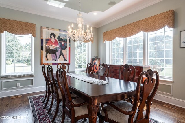 dining space featuring crown molding, a healthy amount of sunlight, dark hardwood / wood-style floors, and a chandelier