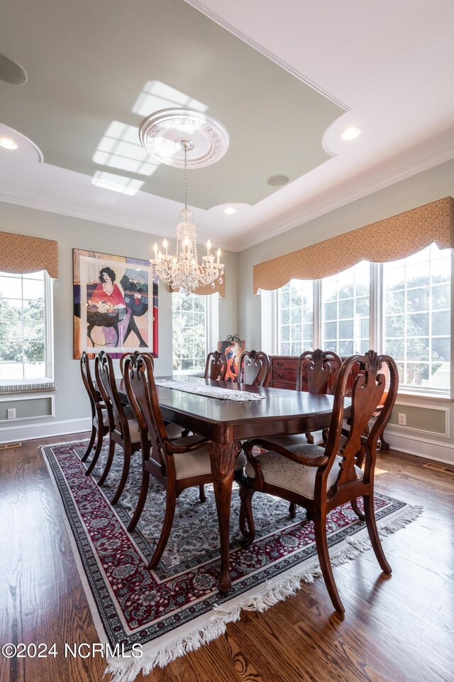 dining space featuring an inviting chandelier, ornamental molding, and dark hardwood / wood-style flooring