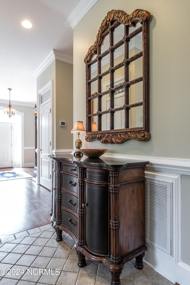 interior space featuring ornamental molding, an inviting chandelier, and light hardwood / wood-style floors