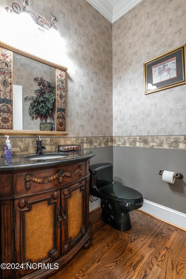 bathroom with vanity, toilet, ornamental molding, and wood-type flooring