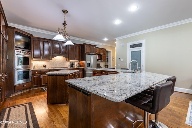 kitchen with wood-type flooring, a center island, and ornamental molding