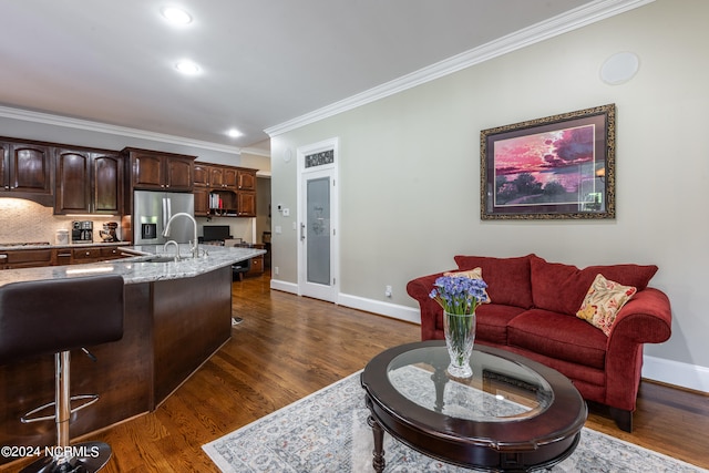 living room with dark wood-type flooring, sink, and ornamental molding