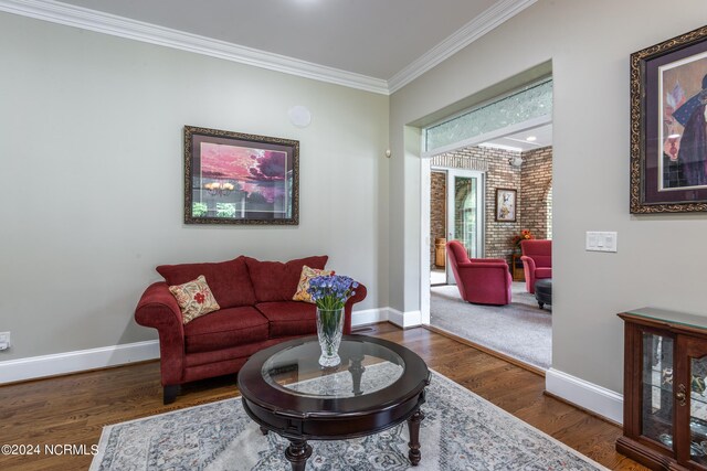 living room with ornamental molding and dark wood-type flooring