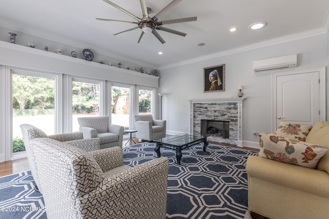 living room featuring a wall mounted AC, hardwood / wood-style flooring, a fireplace, crown molding, and ceiling fan