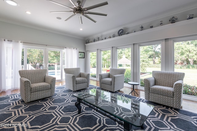 living room with ceiling fan, wood-type flooring, and ornamental molding