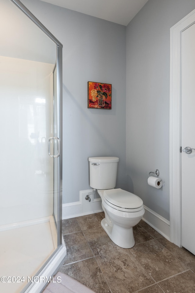 bathroom with an enclosed shower and toilet