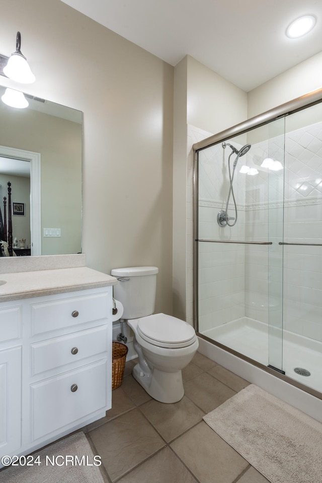 bathroom with vanity, toilet, tile patterned floors, and walk in shower