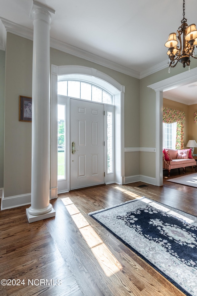 entrance foyer featuring ornate columns, wood-type flooring, and a healthy amount of sunlight