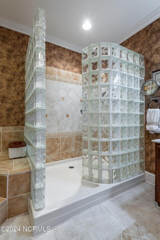 bathroom with tile patterned flooring, a tile shower, and ornamental molding