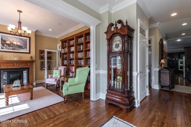 sitting room featuring crown molding, dark hardwood / wood-style floors, and an inviting chandelier