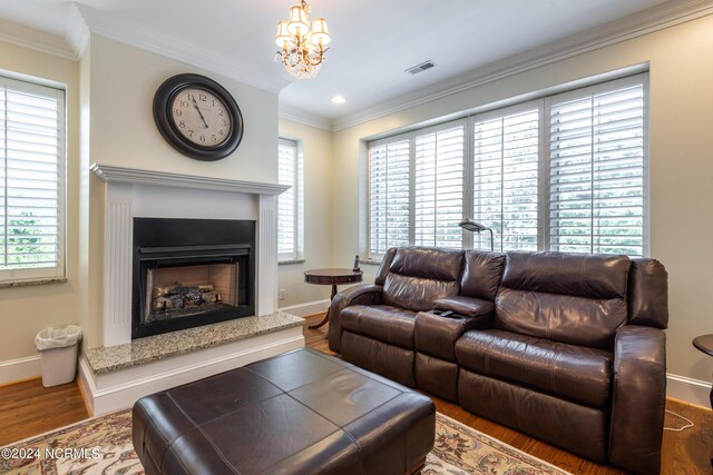 living room with a high end fireplace, dark wood-type flooring, ornamental molding, and plenty of natural light