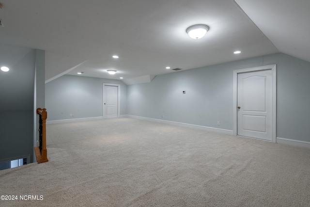 bonus room with lofted ceiling and light colored carpet