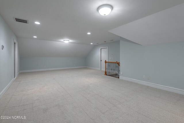 bonus room featuring vaulted ceiling and light colored carpet