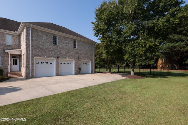 view of side of property with a lawn and a garage