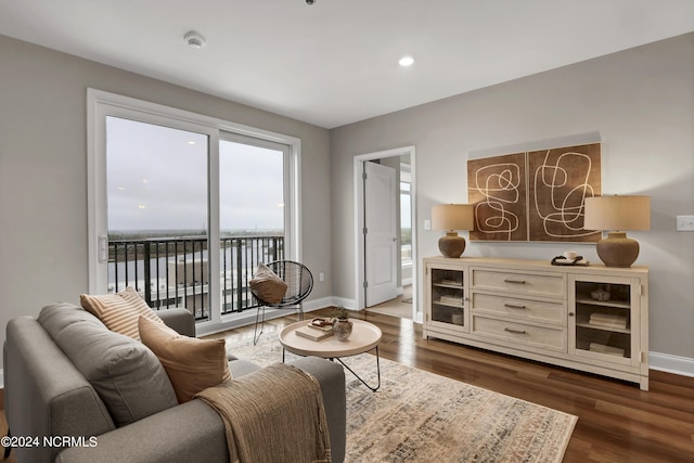 living area with baseboards, dark wood-style flooring, and recessed lighting