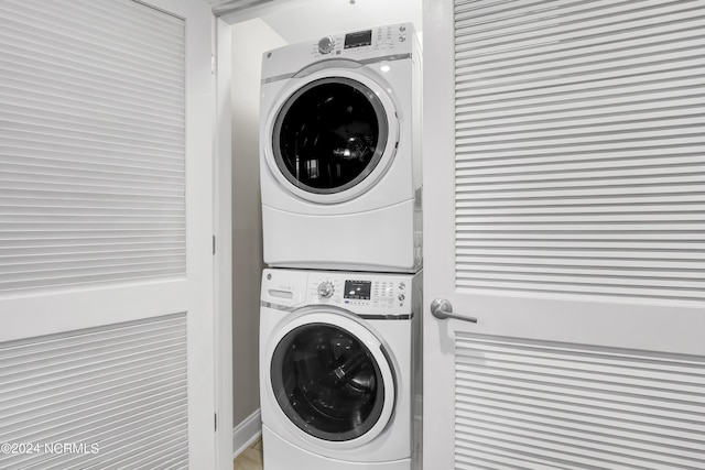 washroom featuring stacked washer / drying machine and laundry area