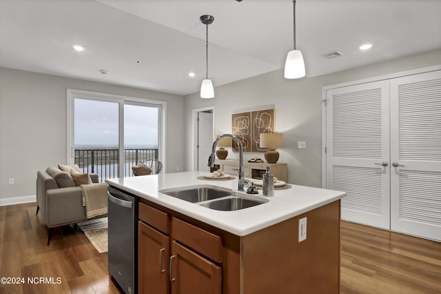 kitchen with a sink, dark wood-style floors, light countertops, dishwasher, and decorative light fixtures