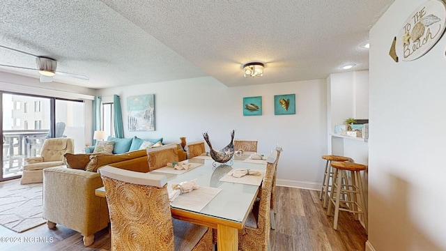 dining space featuring ceiling fan, hardwood / wood-style flooring, and a textured ceiling