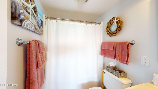 bathroom featuring toilet and a shower with curtain