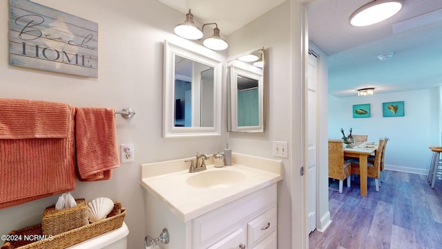 bathroom with vanity, toilet, and hardwood / wood-style flooring