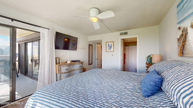 bedroom with ceiling fan, access to exterior, and a textured ceiling