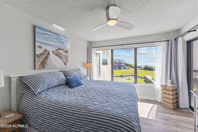 bedroom featuring a textured ceiling, ceiling fan, and light hardwood / wood-style floors