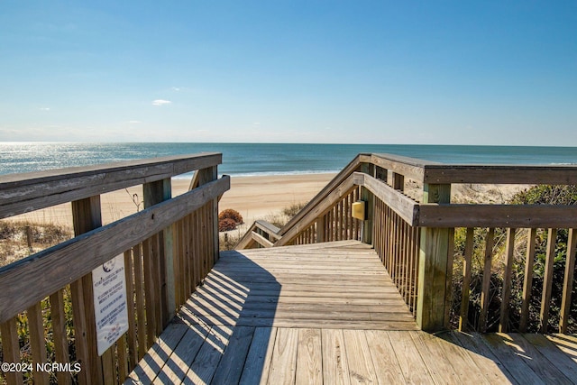 surrounding community with a beach view and a deck with water view