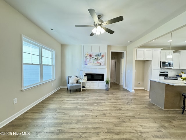 living area featuring ceiling fan and light wood-type flooring