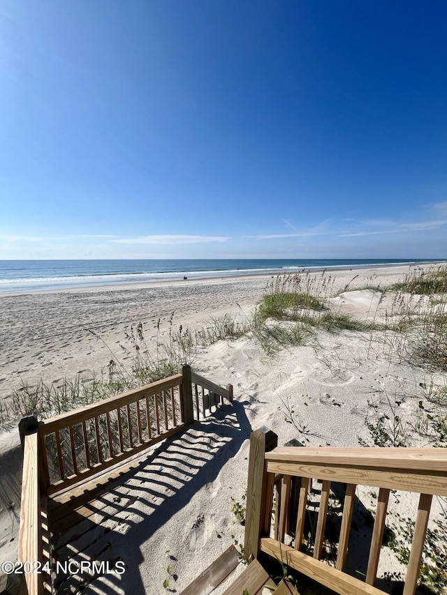 view of property's community with a water view and a view of the beach