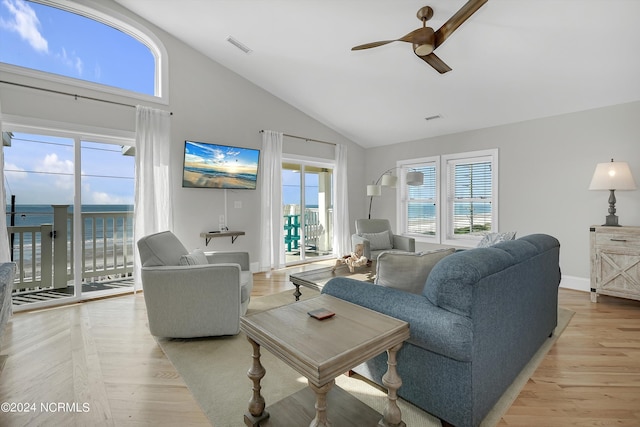 living room featuring ceiling fan, high vaulted ceiling, light wood-style flooring, visible vents, and baseboards